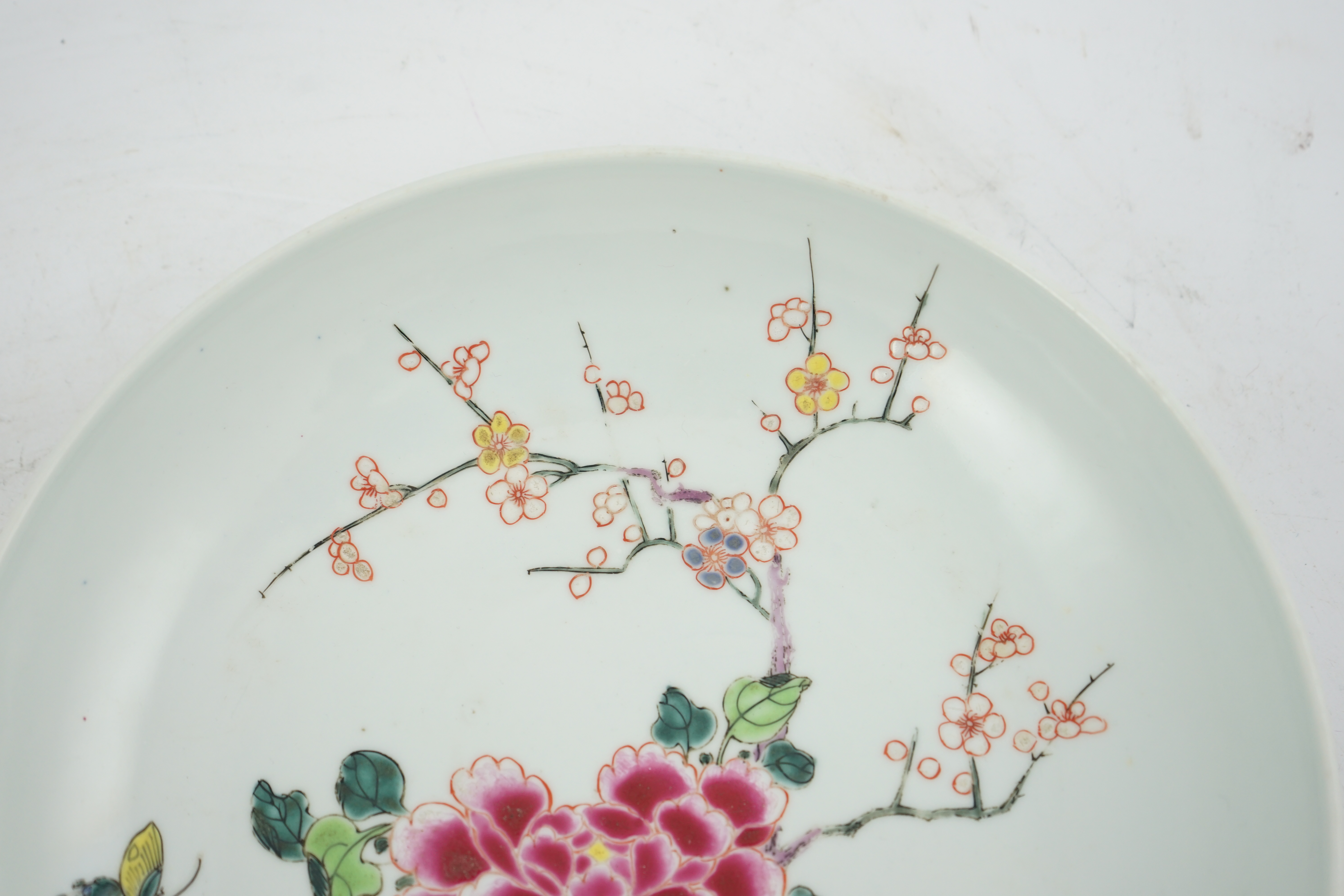 A Chinese famille rose ‘peony and prunus’ saucer dish, Yongzheng mark and period (1723-35)